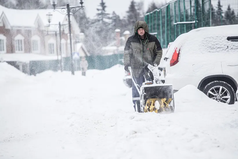 Winterdienst – Schnee wird von einem Gehweg geschaufelt